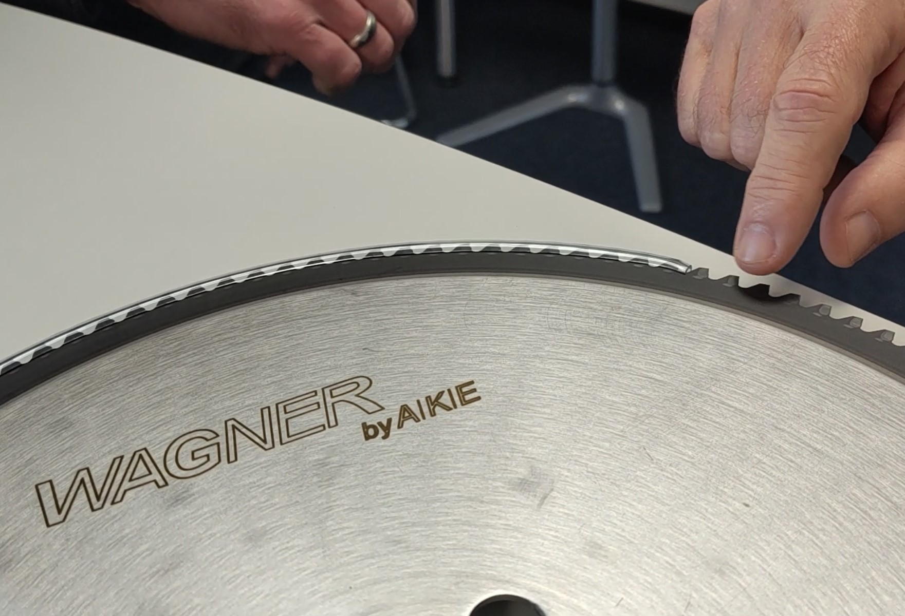 AKE Experte zeigt auf Sägeblatt bei der Beratung